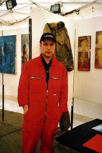 Alex Arnold - aufgenommen anl&auml;sslich der Ausstellung "Kunst im Zelt" 2001. Im Hintergrund sehen Sie meinen alten Overall an der Wand h&auml;ngen. Zur Ausstellung habe ich mir einen neuen gekauft, welcher mittlerweile ebenfalls schon wieder zum Kunstwerk mutiert ist.